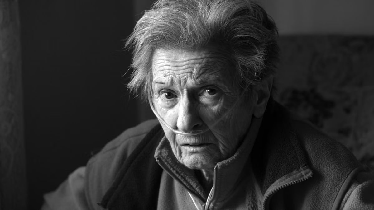 A touching portrait of an elderly woman using oxygen support, showing resilience and strength.
